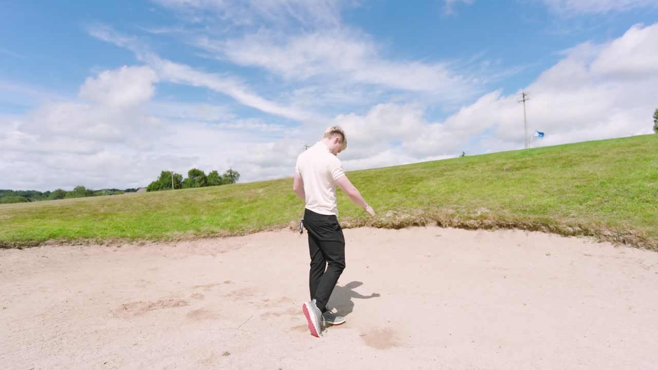 White male golf player wearing white uniform, playing golf and knocking golf ball out on golf course