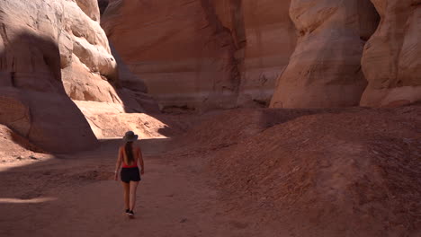 Espalda-De-Una-Mujer-Joven-Caminando-En-El-Cañón-Del-Antílope,-Lago-Powell,-Arizona,-Ee.uu.,-Punto-De-Referencia-Natural-Y-Lugar-De-Turismo-Con-Formaciones-De-Arenisca,-Cámara-Lenta-De-Marco-Completo