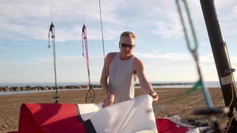 man extending the sail of a hobie cat