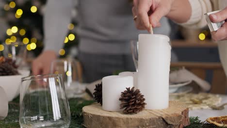 Close up woman lights a candle in Christmas Eve.