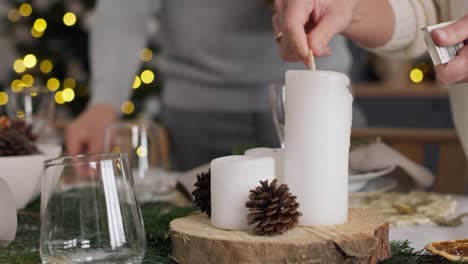 close up woman lights a candle in christmas eve.