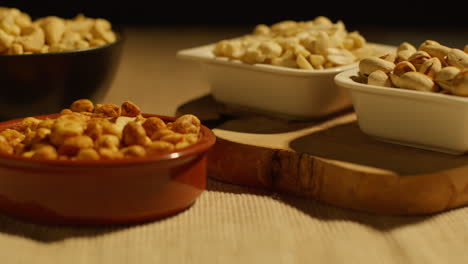 cerca de la mano eligiendo de cuencos de caju tostados secos cacahuetes y pistachos en el estudio 3