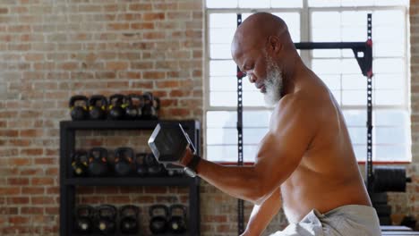 hombre mayor haciendo ejercicio con pesas en el estudio de fitness 4k