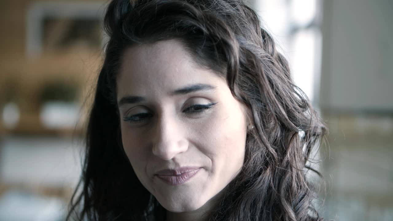 primer plano de una joven morena sonriente con el cabello largo