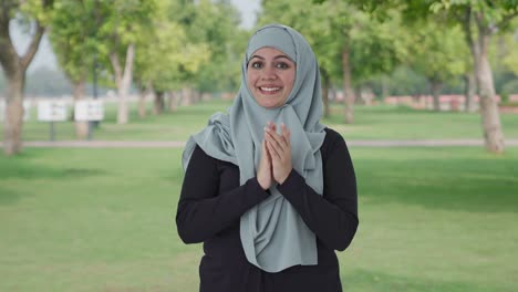 happy muslim woman clapping and appreciating in park