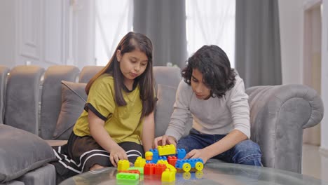 Intelligente-Indische-Kinder-Arrangieren-Bausteine,-Um-Einen-Legoturm-Zu-Bauen