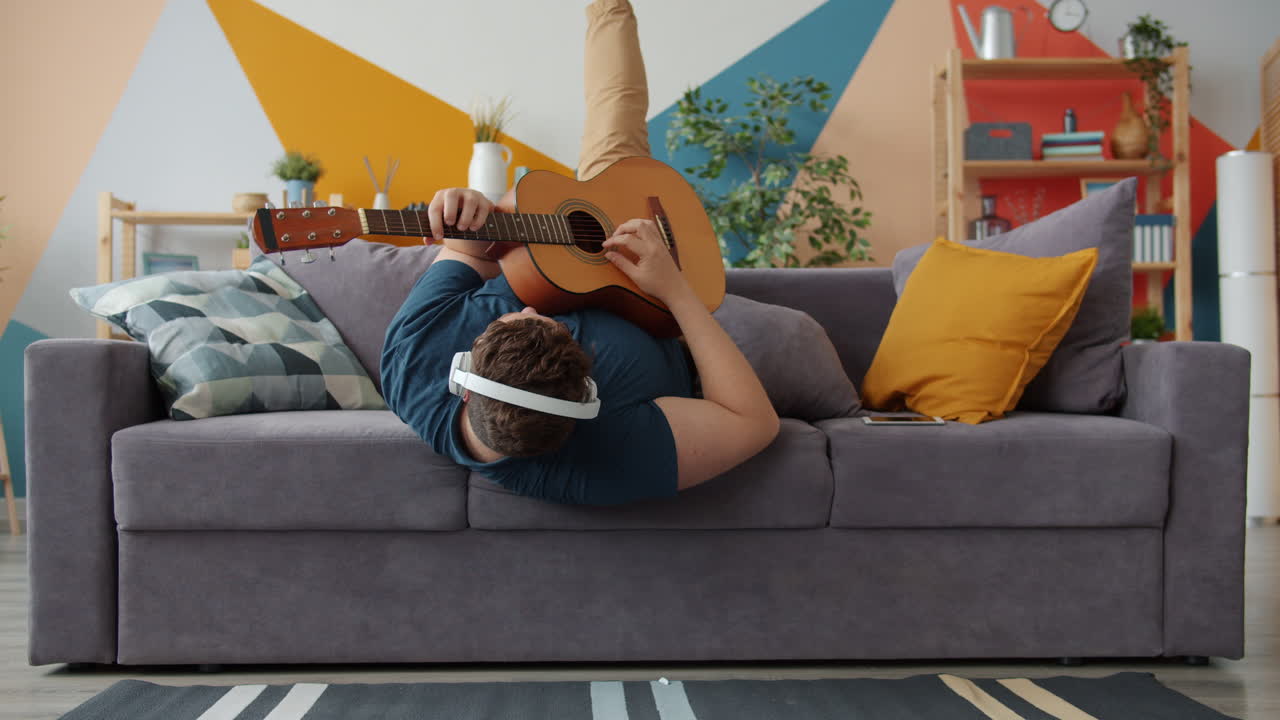 Man Playing Guitar on a Couch