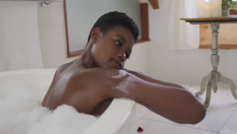 Profile-of-african-american-attractive-woman-relaxing-in-foam-bath-in-bathroom