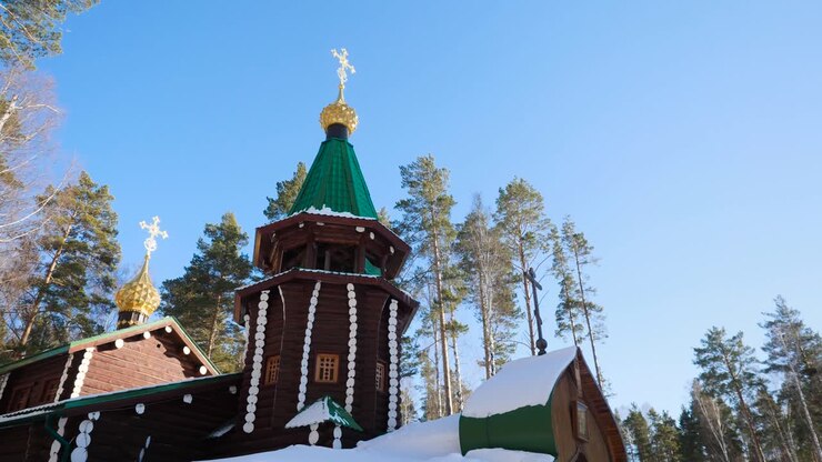 Église orthodoxe en bois dans une forêt hivernale