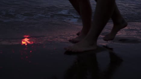 Romantic-couple-walking-in-sea-waves-at-sunset