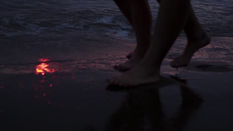 pareja romántica caminando en las olas del mar al atardecer