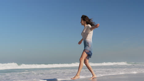 Young-woman-dancing-on-beach-in-the-sunshine-4k