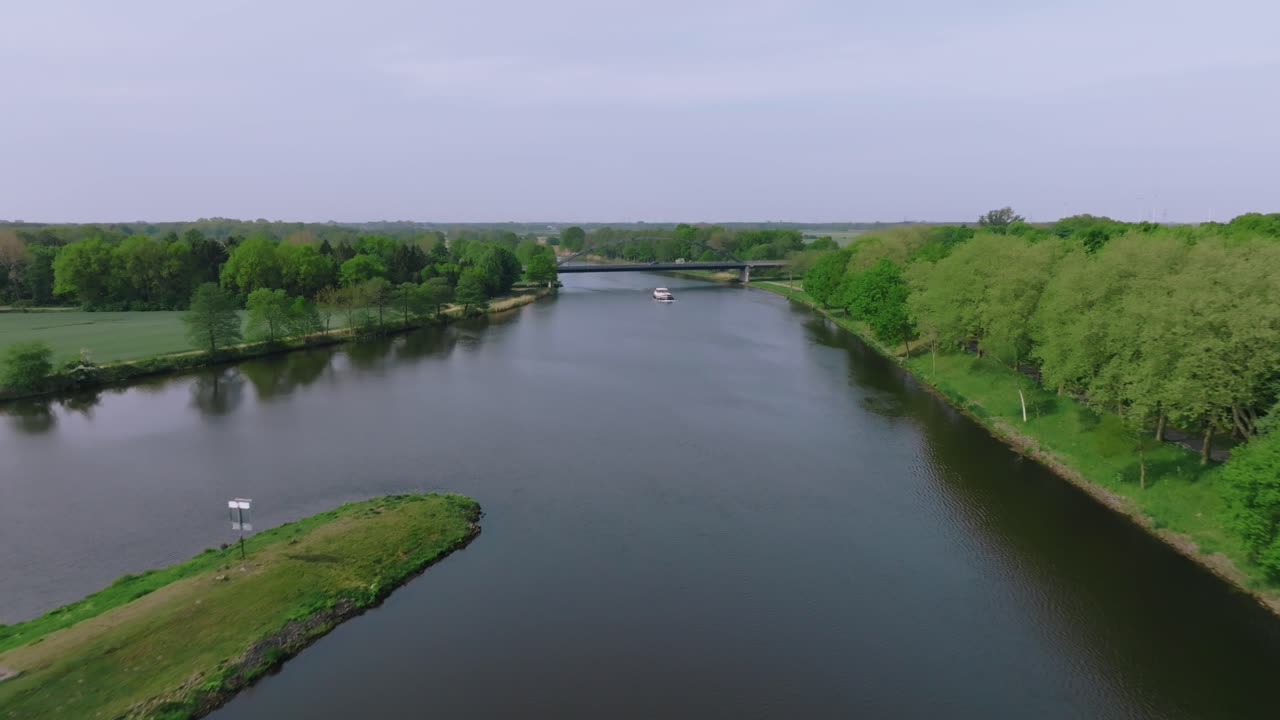 Zoom su un fiume tranquillo circondato da una vegetazione lussureggiante e una foresta in primavera