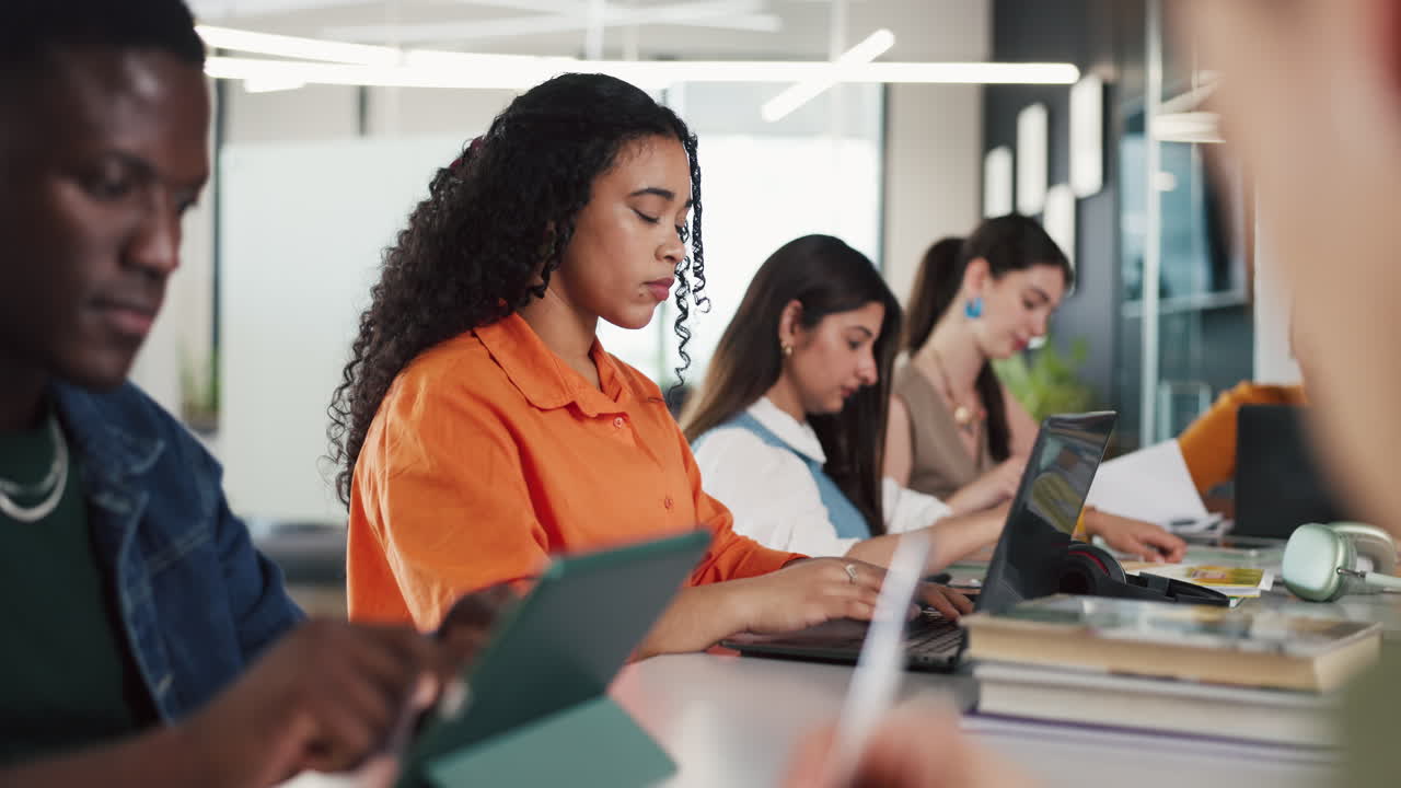 Diverse Students Working on Laptops and Tablets in a Modern Classroom