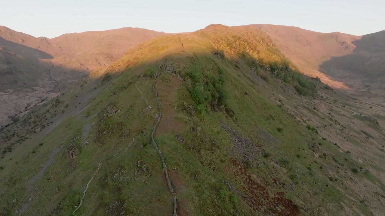 Lago artificiale di Haweswater, Distretto dei Laghi inglese, Cumbria, Regno Unito. Inquadratura ascendente che mostra Kidsty Pike e High Street illuminati dalla luce dell'alba.