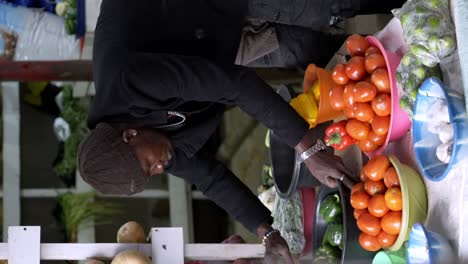 Ein-Verkäufer-Präsentiert-Seine-Waren-Auf-Einem-Markt-In-Afrika-–-Vertikale-Aufnahme