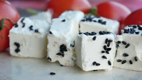 white cheese cubes with black seeds and tomatoes