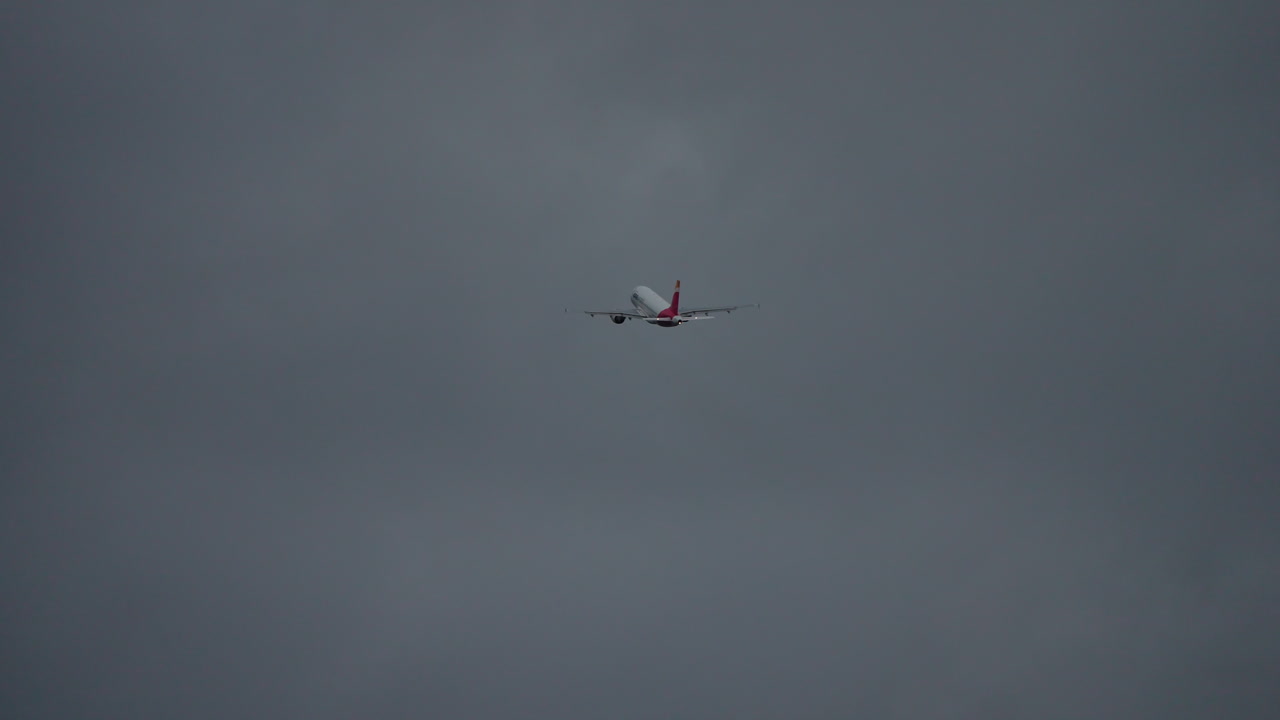 Airplane is soaring through ominous storm clouds, highlighting the power of aviation against a moody sky