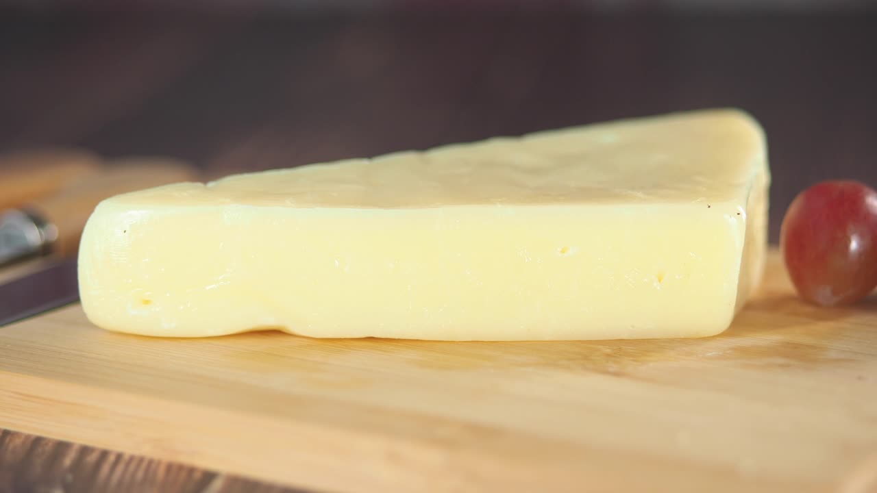 queso y uvas en una tabla para cortar