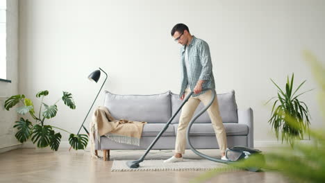 man vacuuming a living room