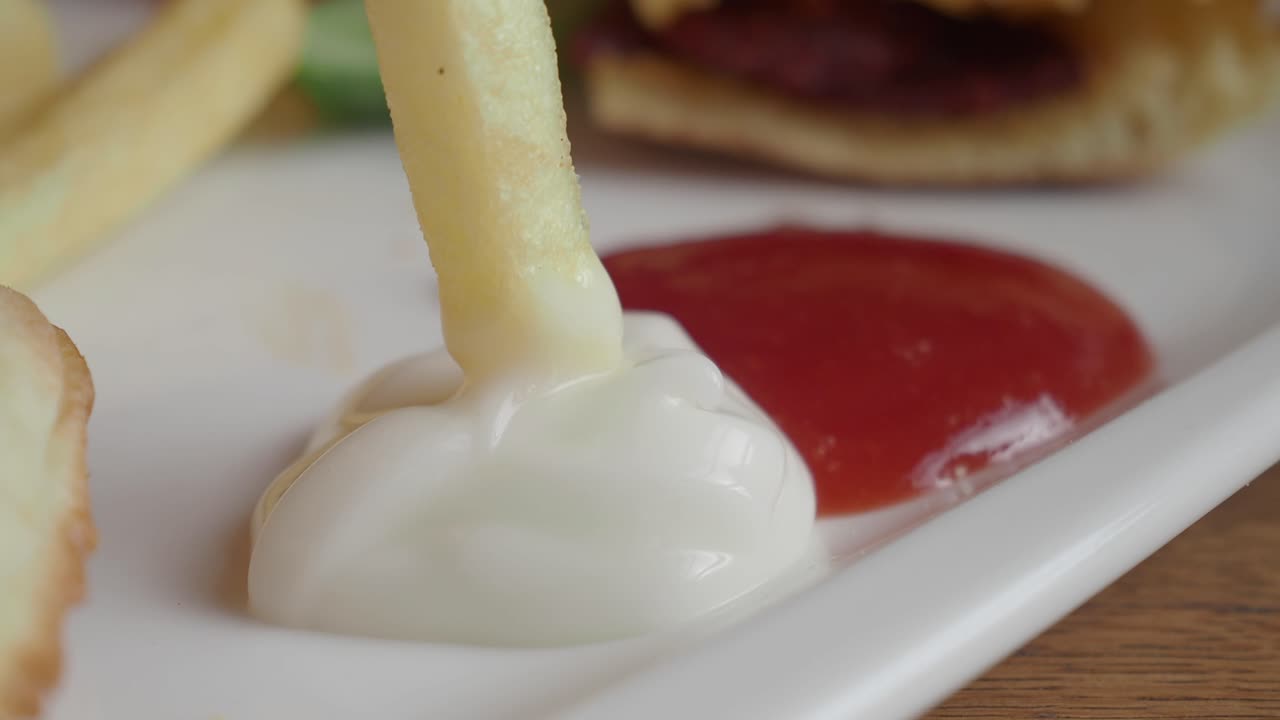 закрыть картошку фри, кетчуп и майонез на тарелке