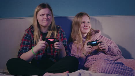 two teen girls gaming together at home