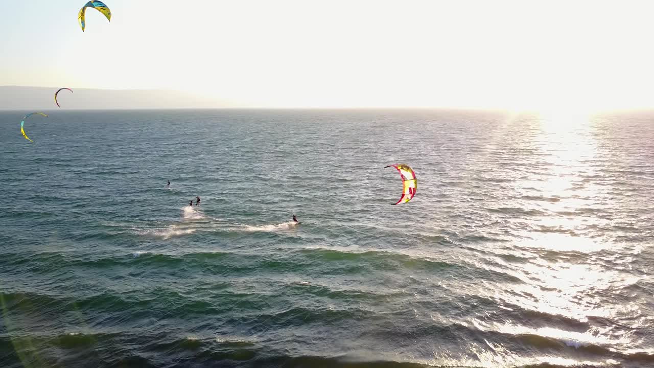kiteboarders saltando y surfeando en un día soleado en el mar de galilea en israel