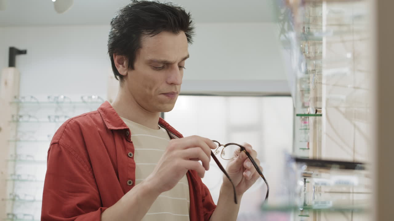 hombre probando gafas en una tienda óptica