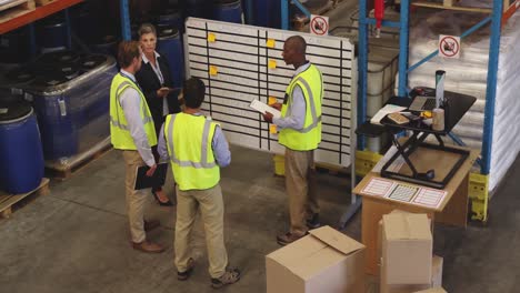 staff meeting at an information board in a warehouse 4k