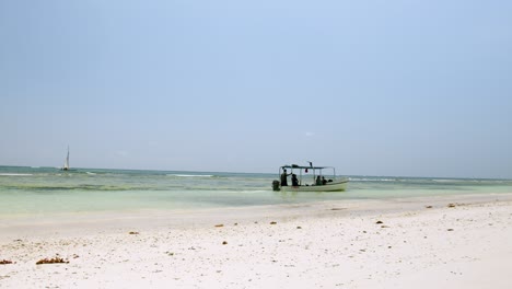 boat at the white sandy shore of diani beach in kenya, africa