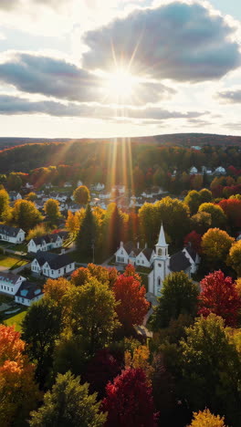 aerial view of an autumn village with a church and sun rays
