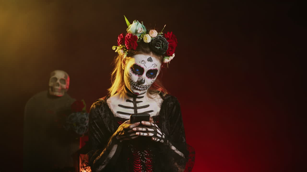 Woman in Day of the Dead makeup using a smartphone