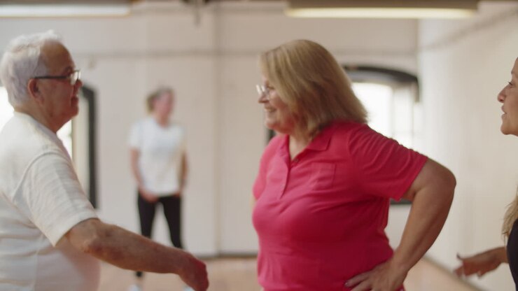 Halvnært billede af et modent par, der lærer at danse med en instruktør.