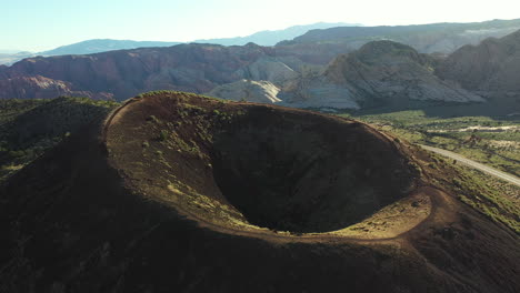 aerial view of lonely person walking on top of cinder cone, inactive volcano crater in snow canyon state park, utah usa