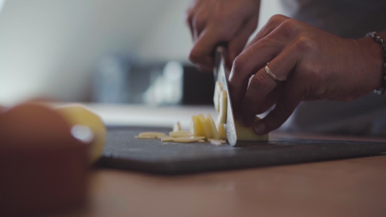 Professional chef slicing potatoes, closeup cinematic slow motion