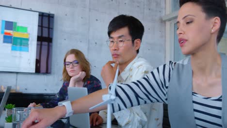 Side-view-of-multi-ethnic-business-people-discussing-over-blueprint-in-the-conference-room-at-modern