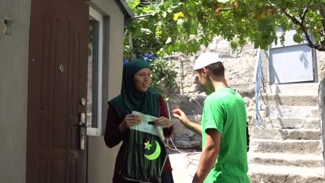 muslim volunteer distributing charity giving and donated food packages. holy month of ramadan