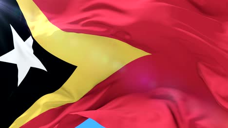 flag of east timor waving at wind with blue sky in slow, loop