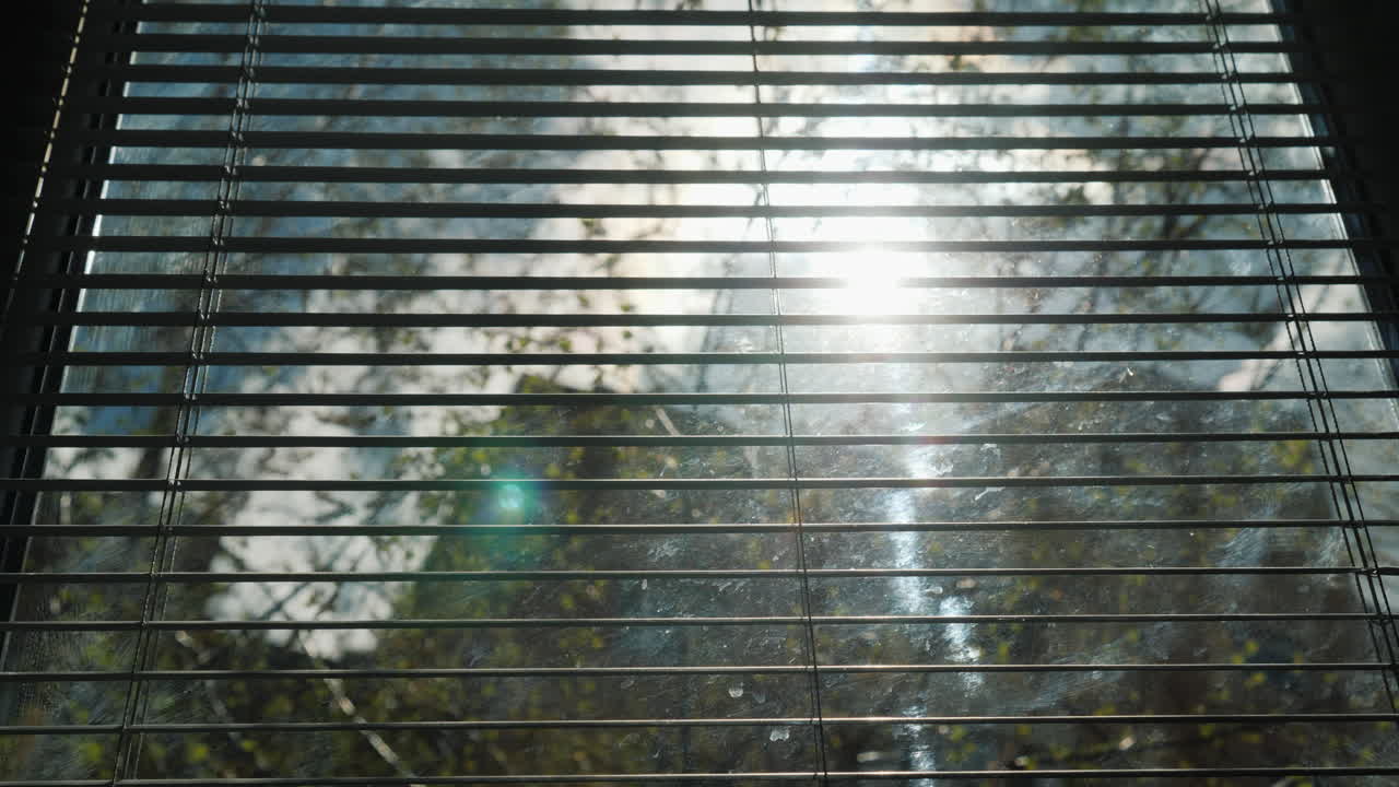 반쯤 닫힌 jalousie 4k 비디오를 통해 봄 햇살이 빛납니다.