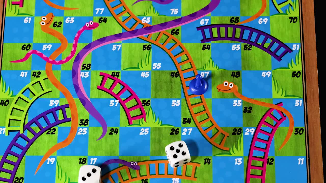 Close-up of hands moving pieces and rolling dice on a vibrant board with snakes and ladders.