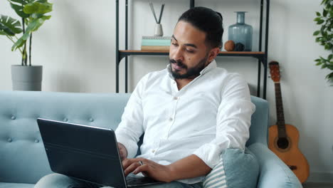 hombre trabajando en una computadora portátil en casa