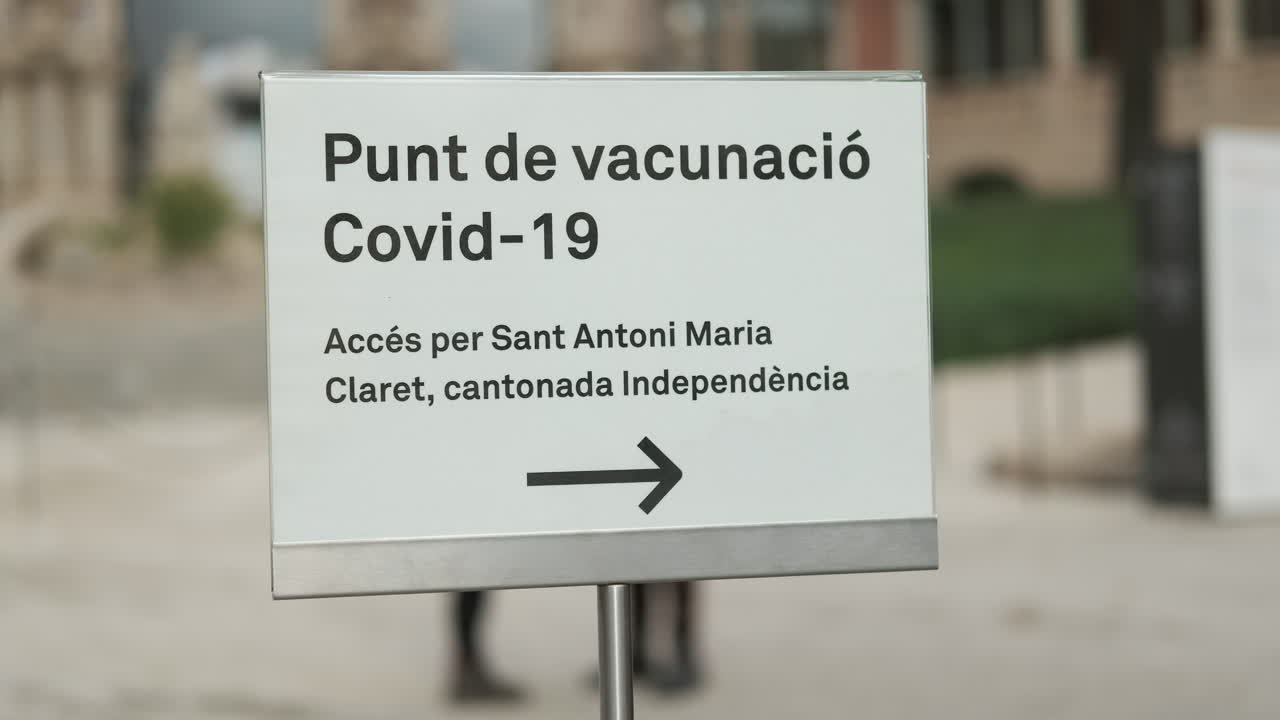 Vaccination point direction sign written in Spanish Language. The Old Hospital de la Santa Creu. Barcelona. Spain