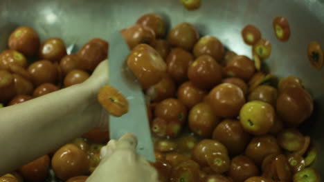 Expert-Chef-Cutting-Lots-Of-Tomatoes-Into-Half