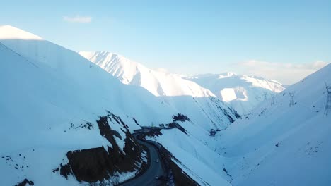 Schneebedeckte-Berglandschaft-Und-Zickzack-Kurvenstraße-In-Der-Natur,-Wilde,-Wunderbare-Landschaft-Auf-Dem-Land,-Roadtrip-Im-Winter,-Sonnenuntergang,-Kaltes-Klima,-Hochland-Im-Nahen-Osten,-Asien,-Iran