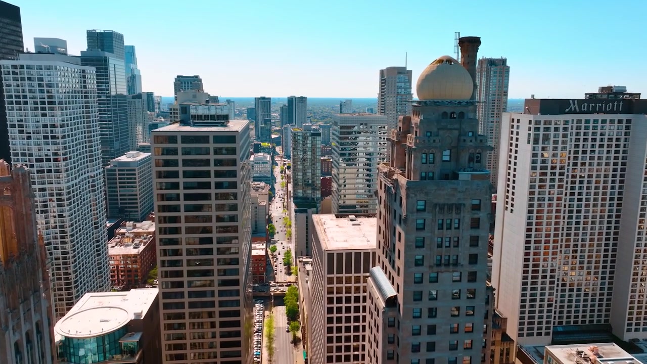 Sobre la larga y recta calle de la hermosa Chicago. Vuelo de dron a lo largo de las torres de la metrópolis.