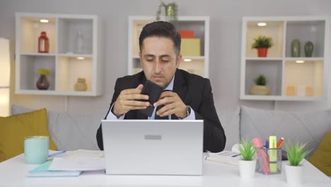 home office worker man showing his empty wallet to the camera.