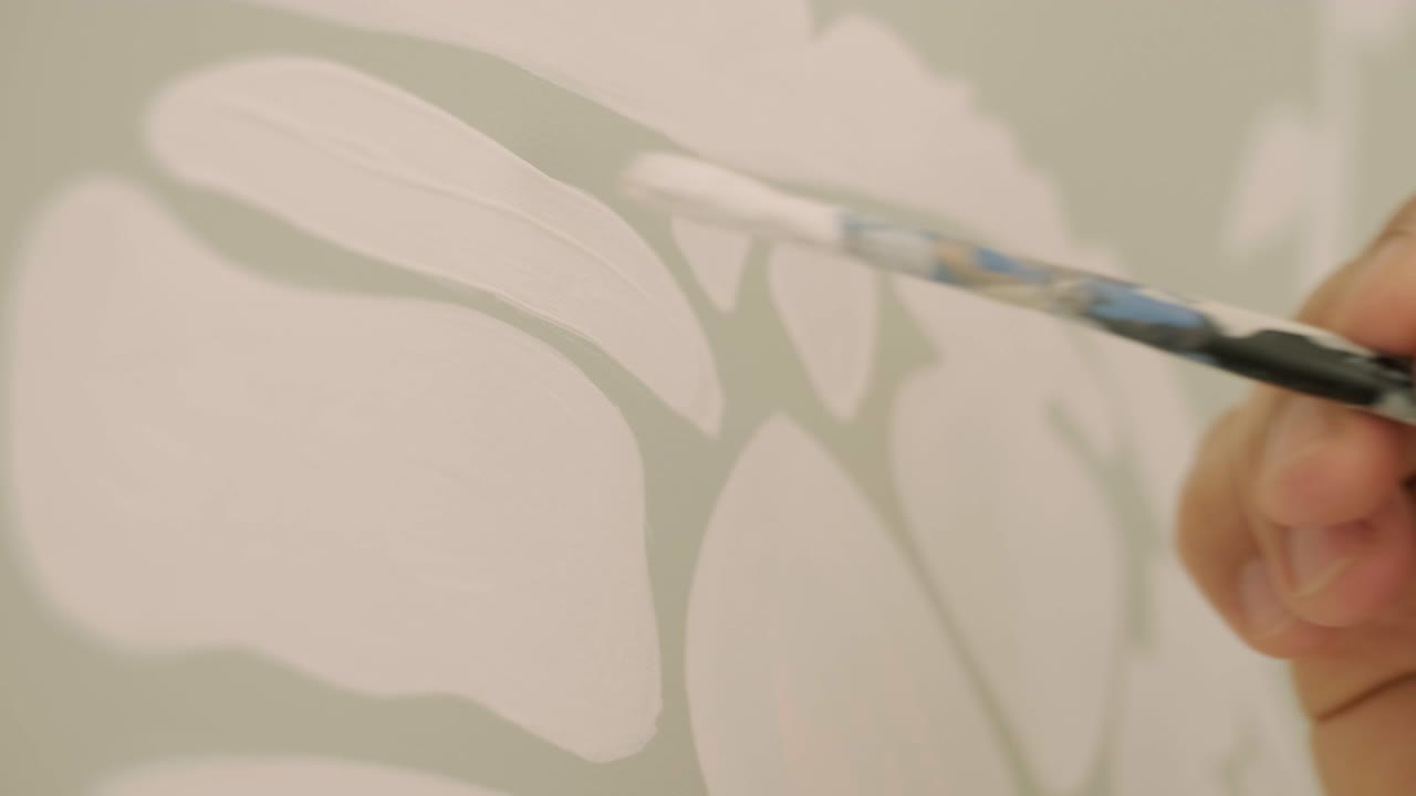 예술가는 어린이 방에서 그림으로 벽을 장식하고 있습니다. 새로운 집에서 벽의 예술 그림. 수리 작업.