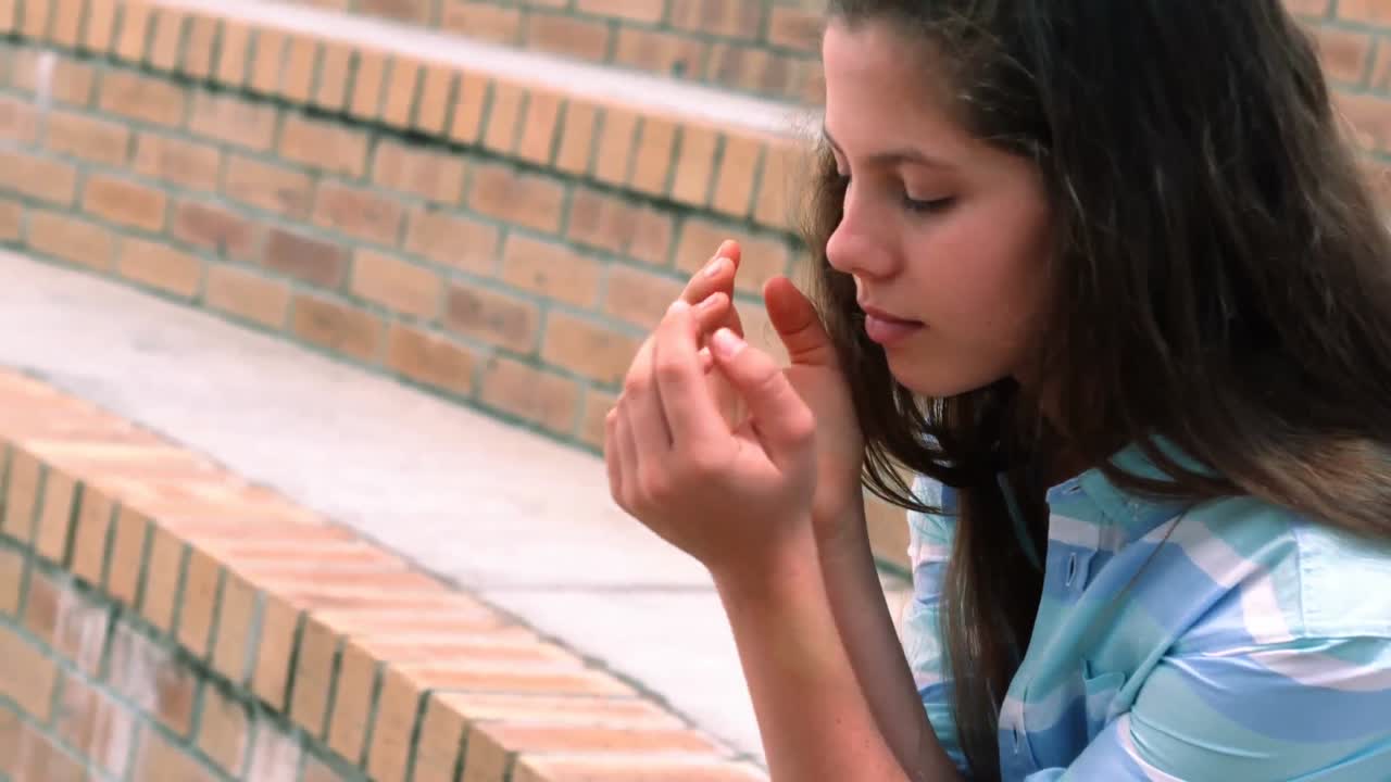 Aluna preocupada sentada no campus