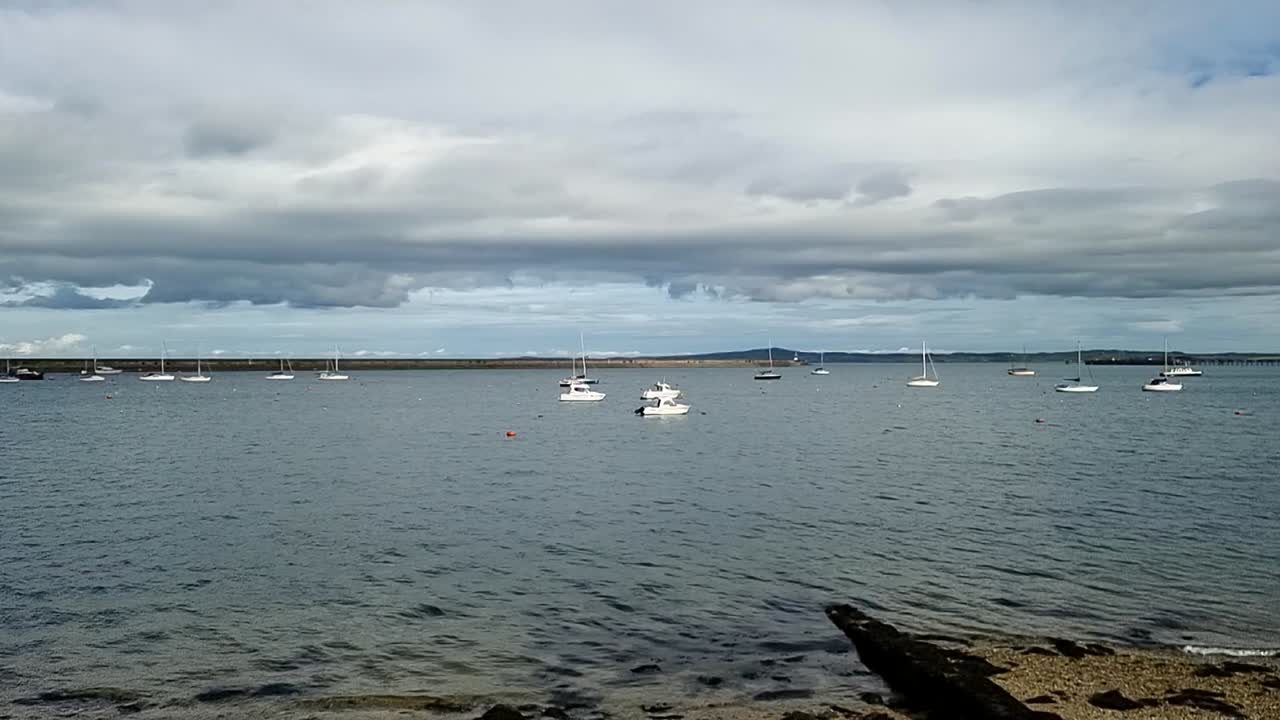 lentamente panorámica a través de la orilla del puerto de holyhead a los transbordadores irlandeses puerto todavía paisaje marino y rompeolas horizonte