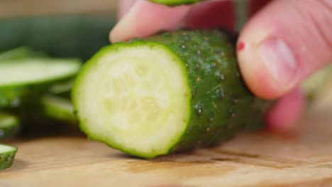 male hands slicing fresh cucumber.